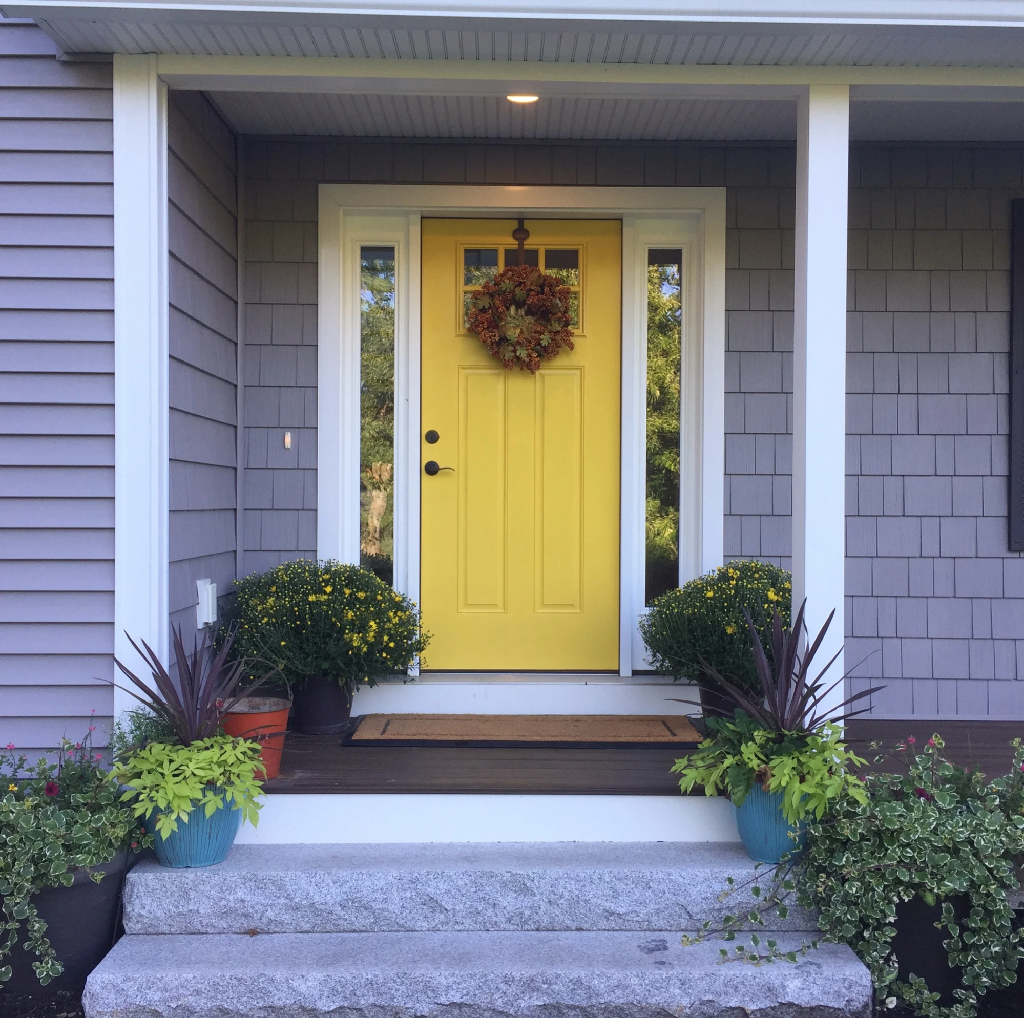 Bright yellow front door with clean white trim by a painting company in Lexington, SC.
